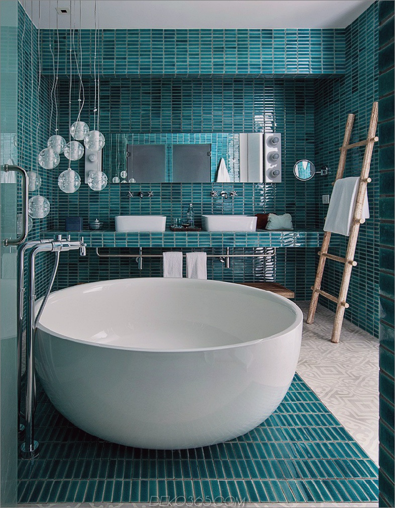 Blaugrünes Badezimmer mit einer kleinen freistehenden Badewanne