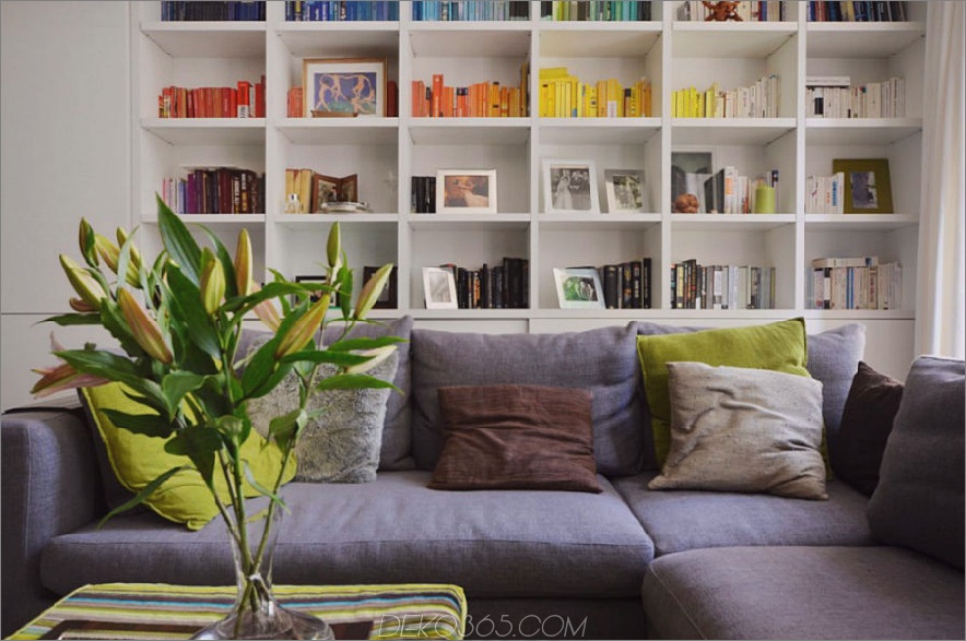 Wohnzimmer-Aufbewahrungswand sorgt für eine farbenfrohe Heimbibliothek. 900x597 Kleines Londoner Apartment mit einem Innenfenster, das einen großen Unterschied macht