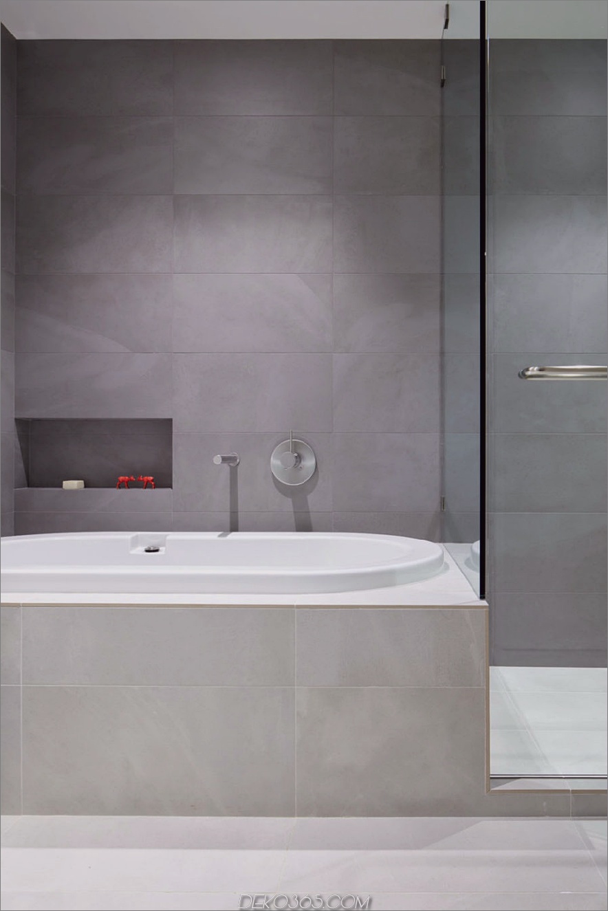 Das moderne, minimalistische Badezimmer verfügt über eine Badewanne und eine Glasduschkabine