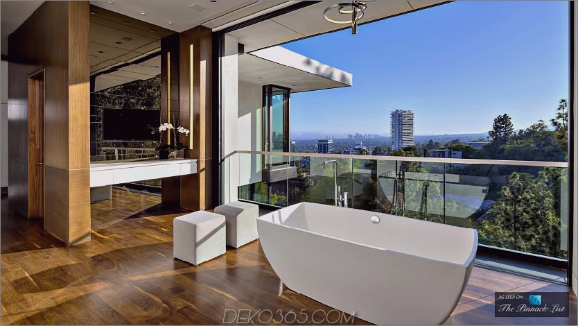 Das luxuriöse Bad wirkt dank der Balkongeländer aus Glas im Innenbereich