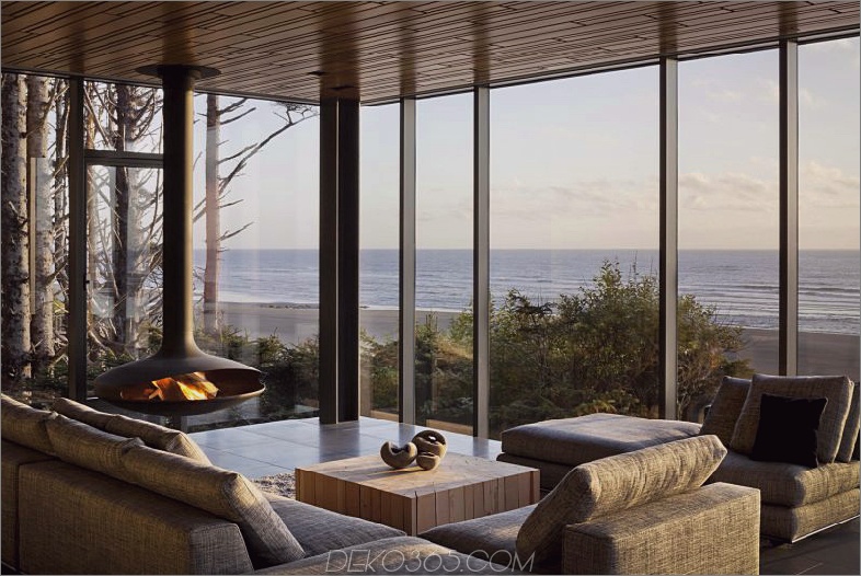 Ein moderner Kaminofen bringt Wärme und Gemütlichkeit in den Raum mit verglasten Sichtwänden
