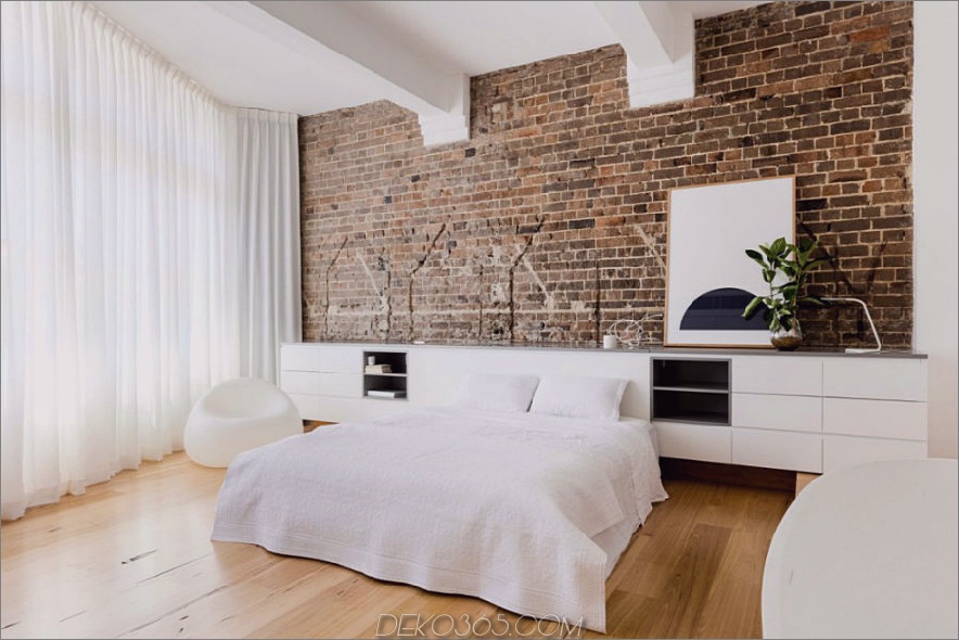 Weiße Wohnung kontrastiert mit altem herausgestelltem Ziegelstein