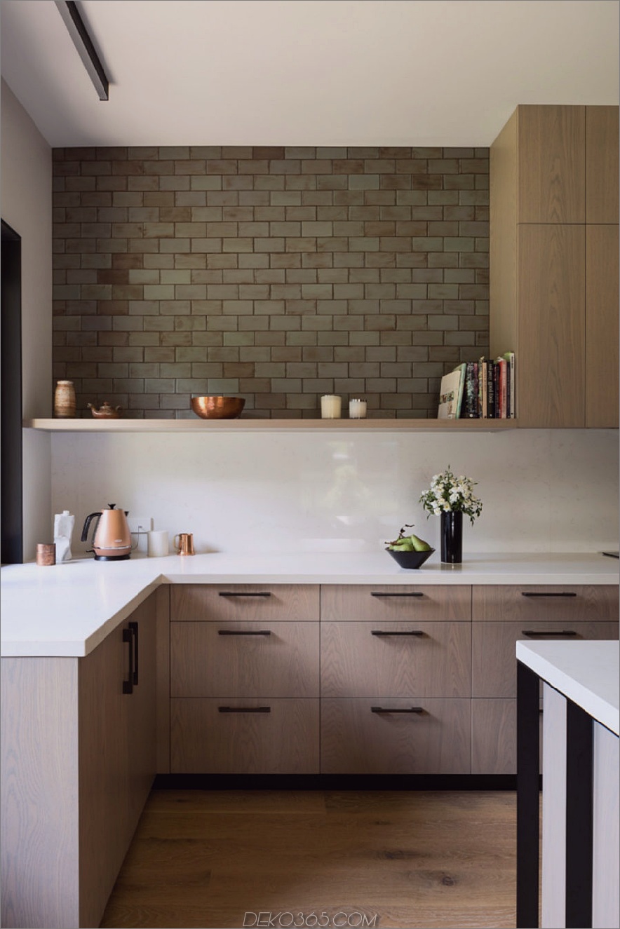 Das einfache Design der Küche umfasst Corian-Arbeitsplatten und obere Regale