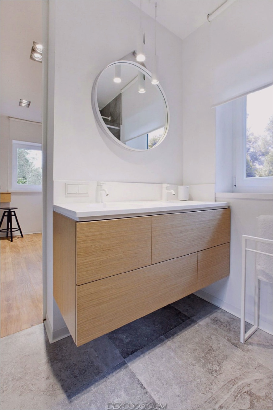 Das bescheidene Badezimmer erinnert an die Küche mit weißer Hardware