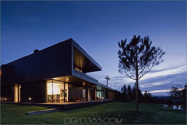 black-home-with-bright-interior-eingebaut in grasbewachsenen hang-3-front-angle-evening.jpg